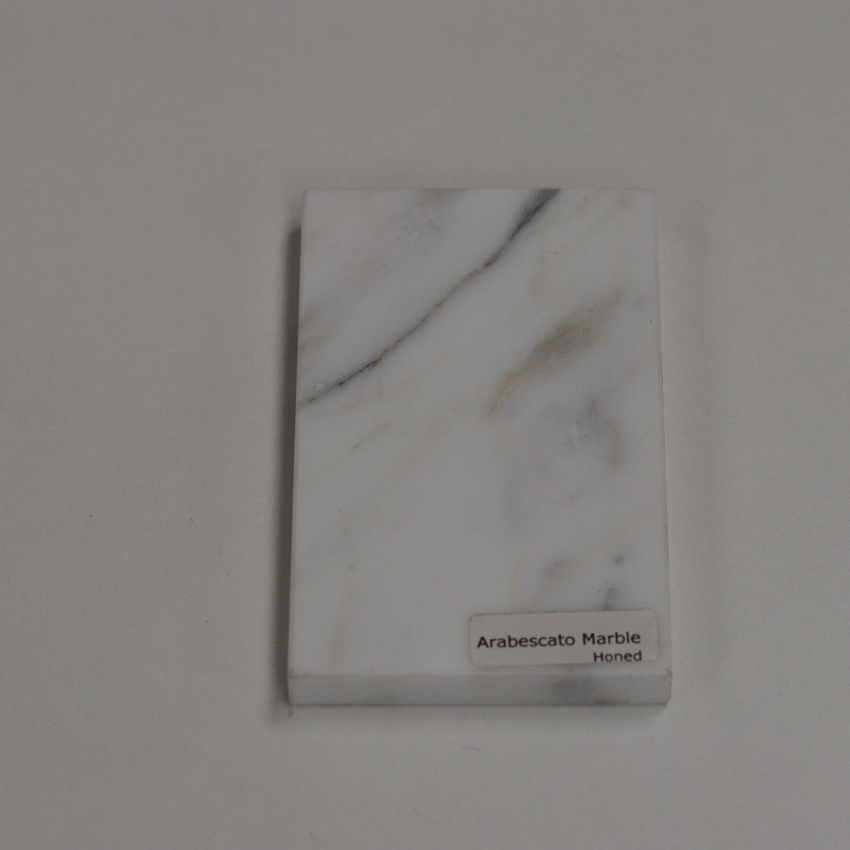 Honed Arabescato — soft matte texture with expressive grey veining