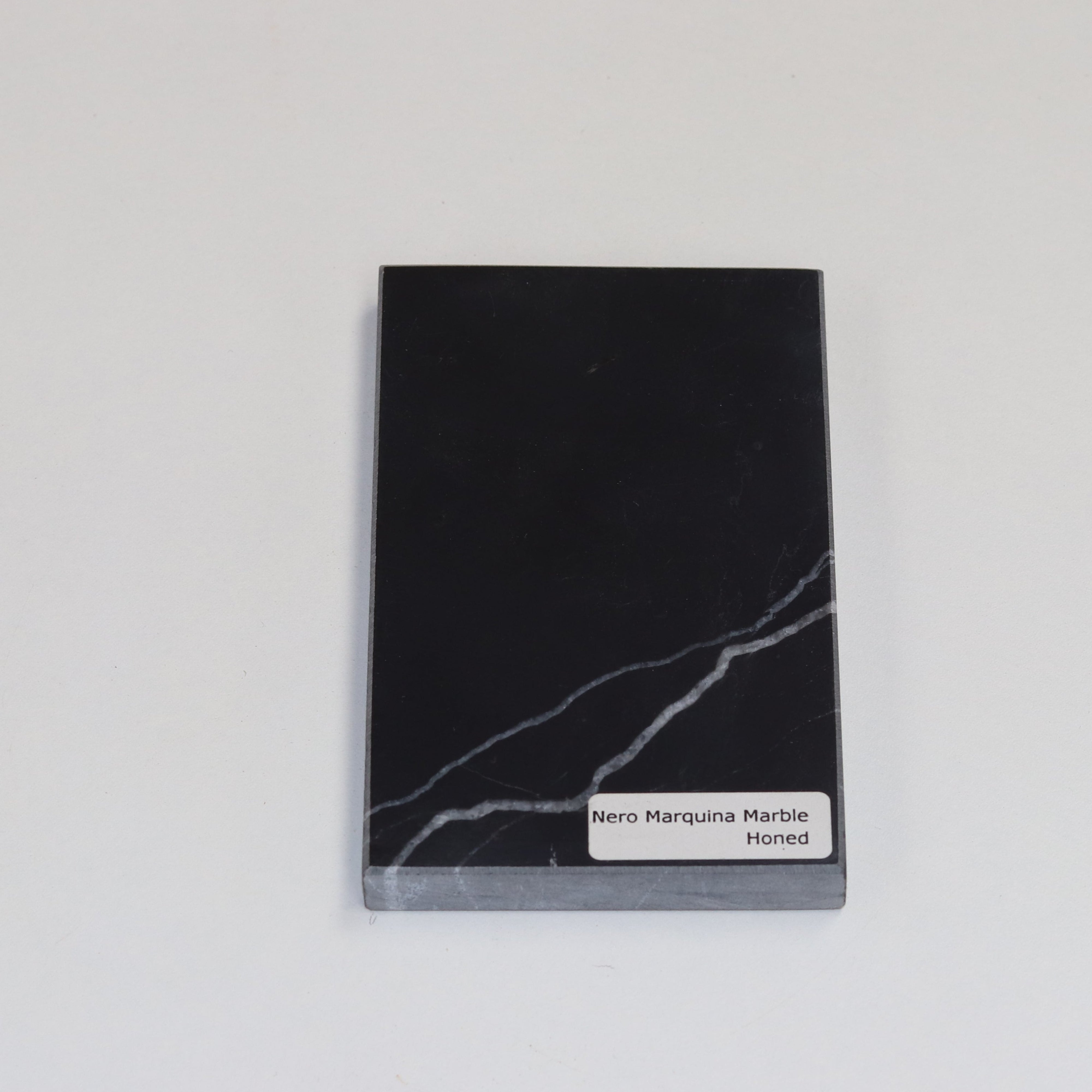 Honed Nero Marquina — soft matte texture with crisp white veining