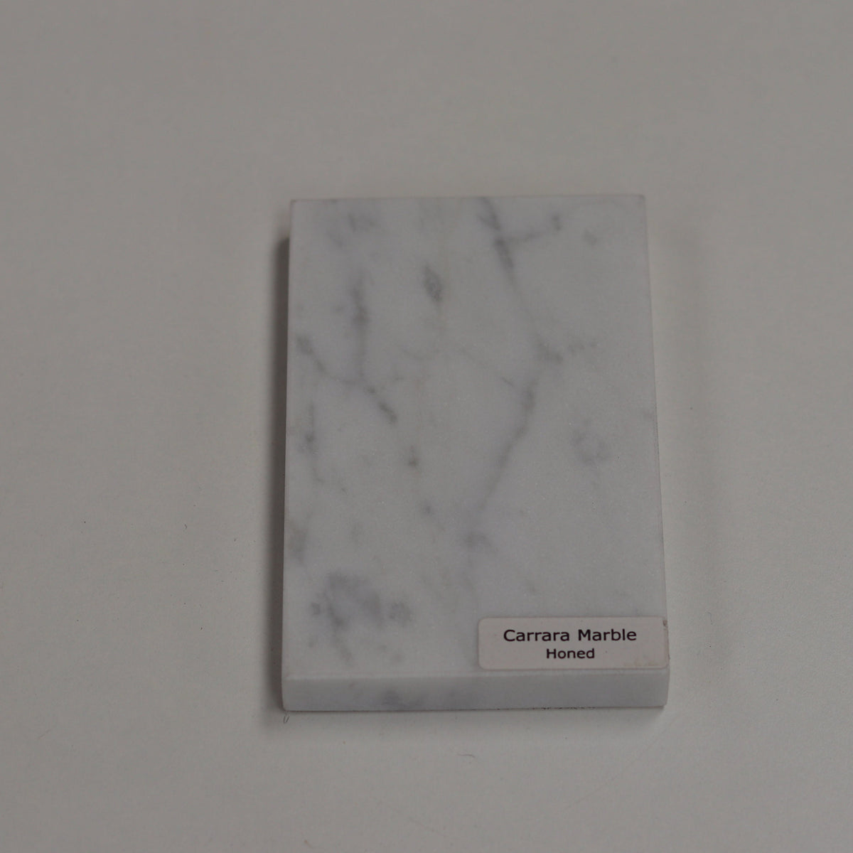 Honed Carrara — soft matte texture with gentle grey veining