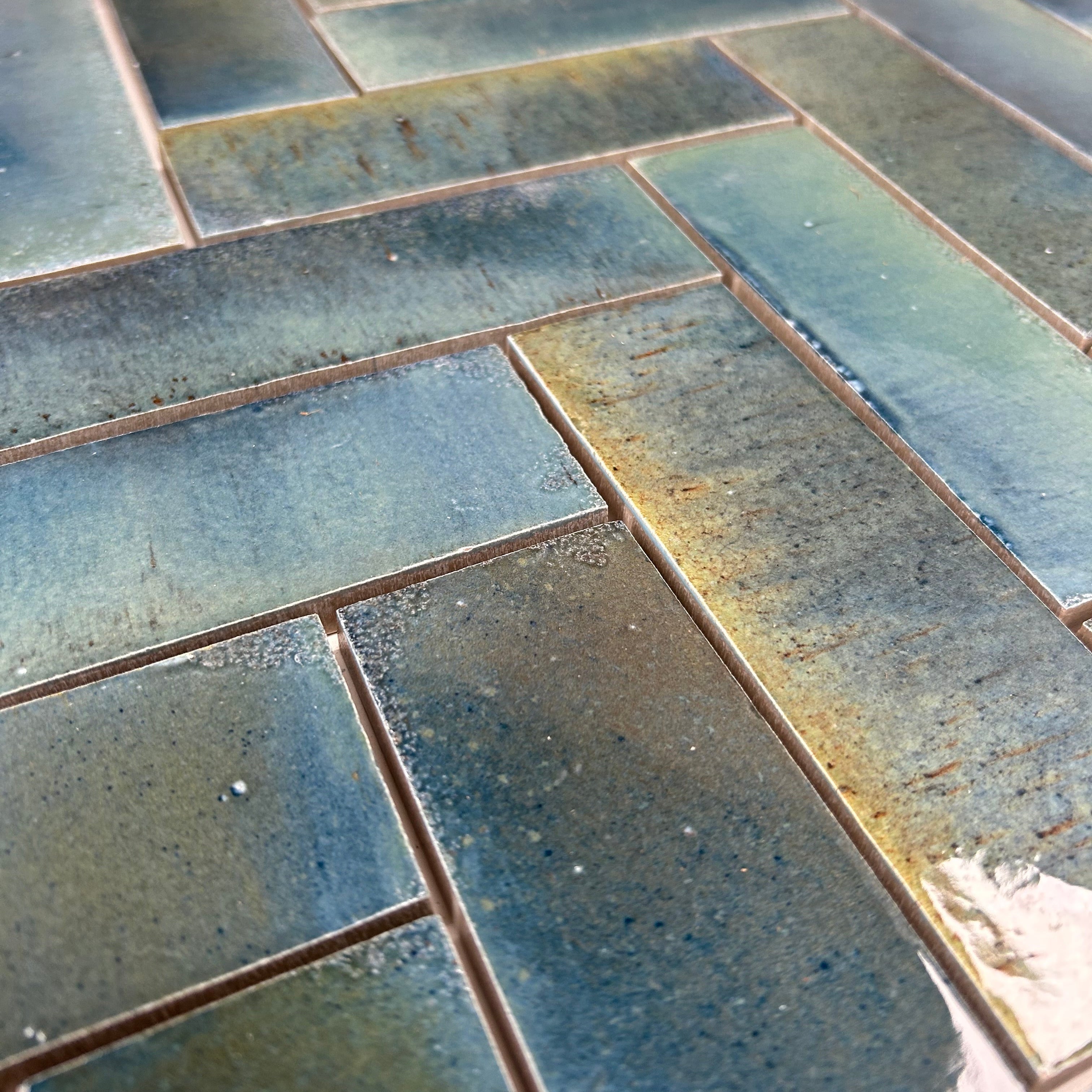 Close-up of blue ceramic tiles with a herringbone pattern